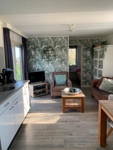 ein Wohnzimmer mit Sofa und Tisch in der Unterkunft Landelijk gelegen chalet aan de Vecht vlakbij Amsterdam in Nigtevecht