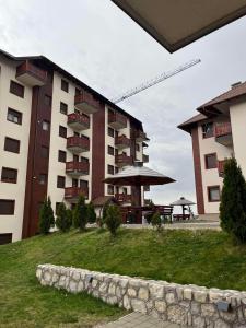 a large building with a table and an umbrella at Dolce apartman Zlatibor in Zlatibor +4 photos