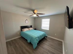 Un dormitorio con una cama y un ventilador de techo. en Englewood Beach Bungalow, en Englewood