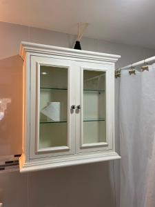 a white cabinet with glass doors in a bathroom at Beautiful Apartment in Coyoacán in Mexico City