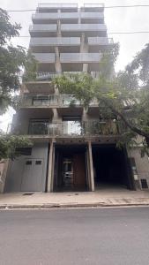 un edificio alto con un garaje delante en Mendoza, en Rosario
