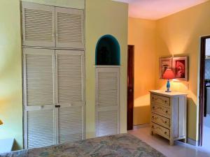 une chambre avec des portes de placard blanches et une commode dans l'établissement Bungalow Tranquilidad 2, à La Manzanilla