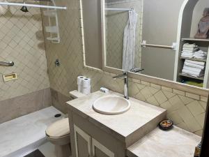 une salle de bain avec un lavabo, des toilettes et un miroir dans l'établissement Bungalow Tranquilidad 2, à La Manzanilla