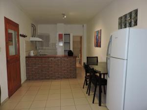 a kitchen with a white refrigerator and a table with chairs at Departamentos Mercedes VM in Villa Mercedes