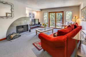 a living room with red furniture and a fireplace at Spacious Top Floor Condo Aspen in Aspen