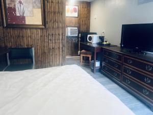a bedroom with a bed and a flat screen tv at Falls Motel in Niagara Falls