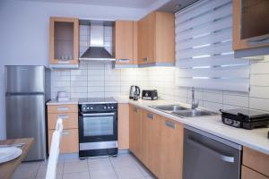 une cuisine avec une cuisinière et un évier dans l'établissement Phoenix Apartment, à Ierápetra