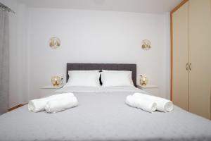 une chambre avec un lit blanc avec deux serviettes dessus dans l'établissement Phoenix Apartment, à Ierápetra 14 autres photos