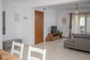 un salon avec un canapé et une télévision dans l'établissement Phoenix Apartment, à Ierápetra