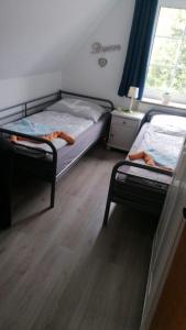 a bedroom with two bunk beds and a window at Ferienhaus FRIESENNEST in Norden