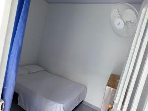 a small room with a bed and a fan at Villacentro in Estación El Salto