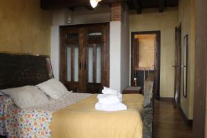 a bedroom with a bed with white towels on it at Las cabachuelas casas rurales in San Miguel de Valero