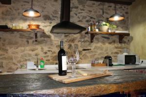 a bottle of wine and a wine glass on a counter at Las cabachuelas casas rurales in San Miguel de Valero