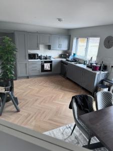 a kitchen with white cabinets and a wooden floor at Double bedroom with private bathroom close to city center in Cork