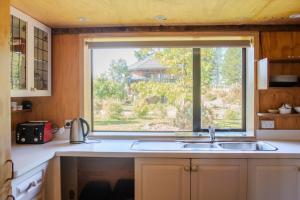 a kitchen with a sink and a large window at The Treehouse Branch in Hanmer Springs