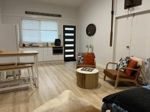 a living room with a table and chairs and a kitchen at South West Rocks Gap Beach Studio in Arakoon