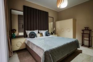 ein Schlafzimmer mit einem großen Bett und blauen Kissen in der Unterkunft Luna Apartament in Mamaia Nord – Năvodari