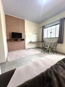 uma sala de estar com uma televisão e uma mesa e cadeiras em Residencial Davisis - Parada do Jalapão em Palmas