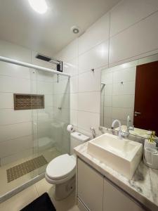a bathroom with a sink and a toilet and a mirror at Ótimo Apartamento em Vila Velha in Vila Velha +7 photos
