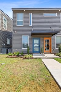 una casa con una puerta azul y un patio en Boudin House Luxury Amenities Prime Location WiFi, en Lafayette