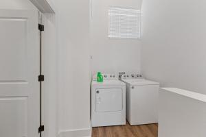 Un lavadero blanco con dos lavados y una estufa. en Boudin House Luxury Amenities Prime Location WiFi, en Lafayette 17 fotos más