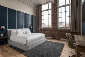 a bedroom with a bed and a desk and windows at The Skowhegan By Kasa in Skowhegan +21 photos
