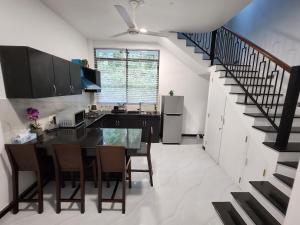 a kitchen with a dining room table and a staircase at Eagle Nest in Kadirandola