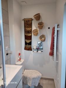 a bathroom with a toilet and baskets on the wall at nature in Gardanne