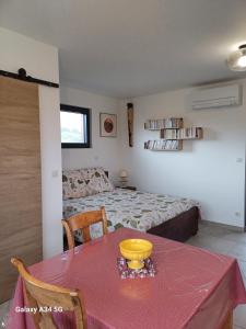 a bedroom with a table and a bed with a red table cloth at nature in Gardanne +7 photos