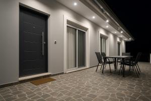 a room with a table and chairs and a door at Johns villa in Artemida +1 photo