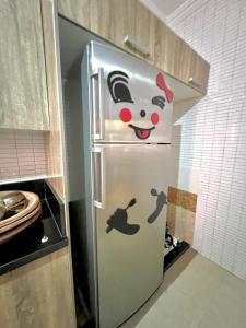 Un refrigerador con una imagen de Hello Kitty en una cocina. en Family quite apart full furnished, en Oulad Akkou