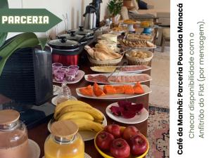 a buffet with plates of fruit and other food at Flat ao lado da Praia - Rifaina in Rifaina