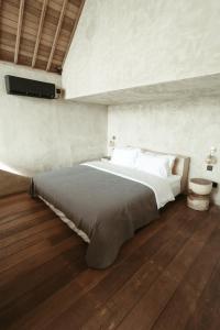 a bedroom with a large bed and a tv on the wall at The Iggy Hotel Seseh Loft 8 in Cemagi