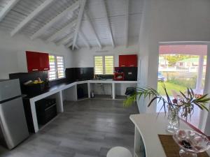 a kitchen with white counters and red cabinets at O paradis de Beauplan in Port-Louis