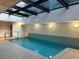 a swimming pool in a building with blue water at Beautiful Apartment w sea view in Auckland