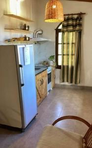 a kitchen with a white refrigerator and a stove at Departamento Santa Rita in Esquina