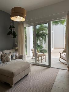 プンタ・カナにあるRelax in Cana Pearl, Punta Canaのソファとガラスの引き戸のあるリビングルーム +18枚の写真