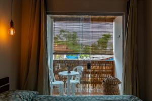 マラウにあるLofts da Vila BGのテーブルと椅子と窓のある部屋