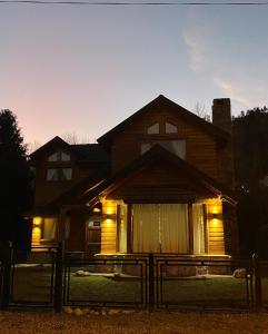 Una casa con luces en la parte delantera. en Cabaña Wefko - San Martin de los Andes, en San Martín de los Andes