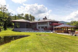 a large house with a pond in front of it at Sunrise - W Glade J-1 in Killington