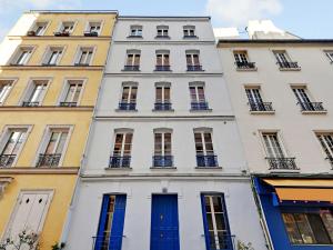 un edificio alto de color blanco con puertas y ventanas azules en Classy studio- Gare de Lyon Bastille, en París 5 fotos más