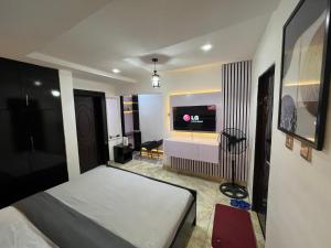 a bedroom with a bed and a flat screen tv at Konar-Apts, Cozy Room with private kitchen, City view Balcony, 24hrs power, Security, Wifi, Gwarinpa Express by Dawaki Junction in Gwarinpa