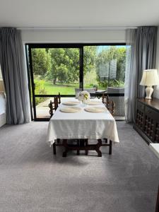 a dining room with a table and a large window at The Gate House in Tauranga