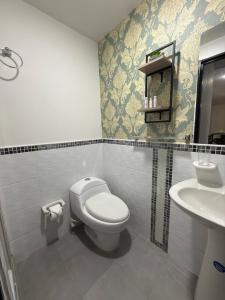 a bathroom with a toilet and a sink at Granada Luxury Loft in Cali