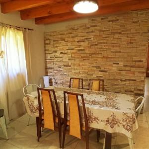 mesa de comedor con sillas y pared de ladrillo en Cabaña Wefko - San Martin de los Andes, en San Martín de los Andes 10 fotos más