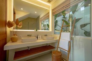 a bathroom with two sinks and a mirror at Villa Pia Pererenan in Cemagi
