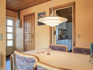 a dining room with a table and chairs and a light fixture at 4 person holiday home in Allinge-By Traum in Allinge