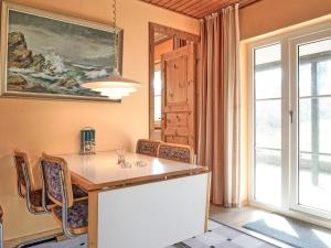 a dining room with a table and chairs and a window at 4 person holiday home in Allinge-By Traum in Allinge +9 photos