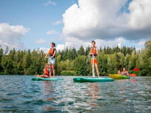 a group of people on paddle boards in the water at The Brookside Escape in Antoing