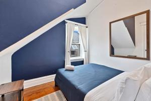 a blue and white bedroom with a bed and a mirror at Vintage 3 Bed Condo in Chicagolands Trendy Berwyn condo in Berwyn +18 photos